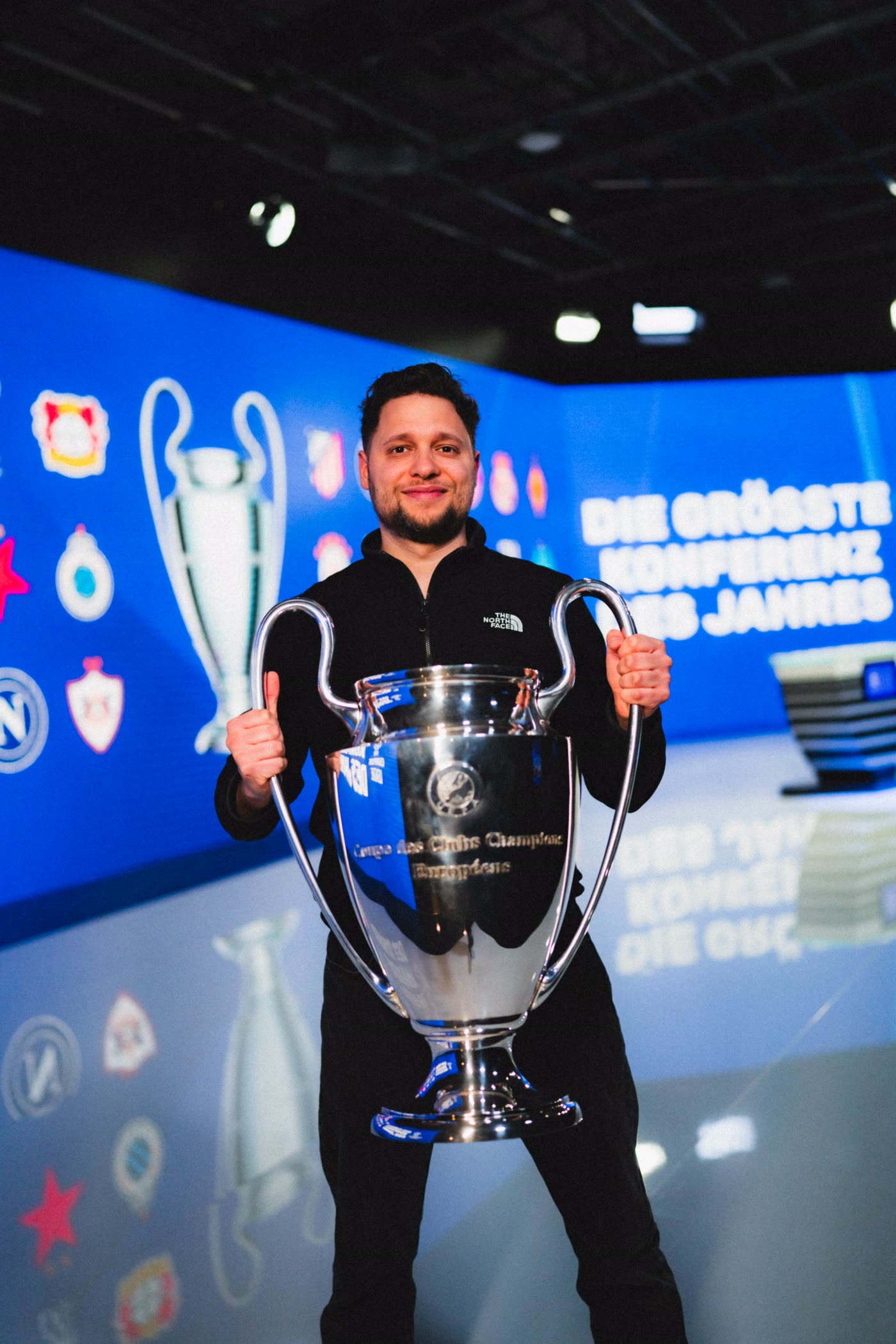 Karim Ali mit dem Champions-League-Pokal im DAZN-Studio.